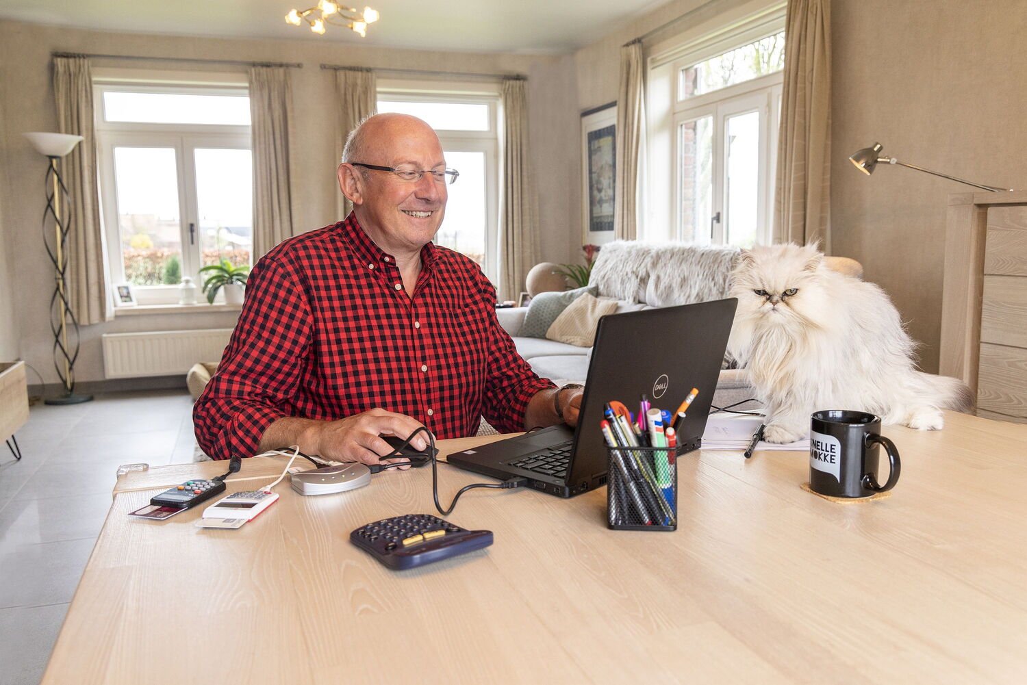 man die thuiswerkt met kat naast zich