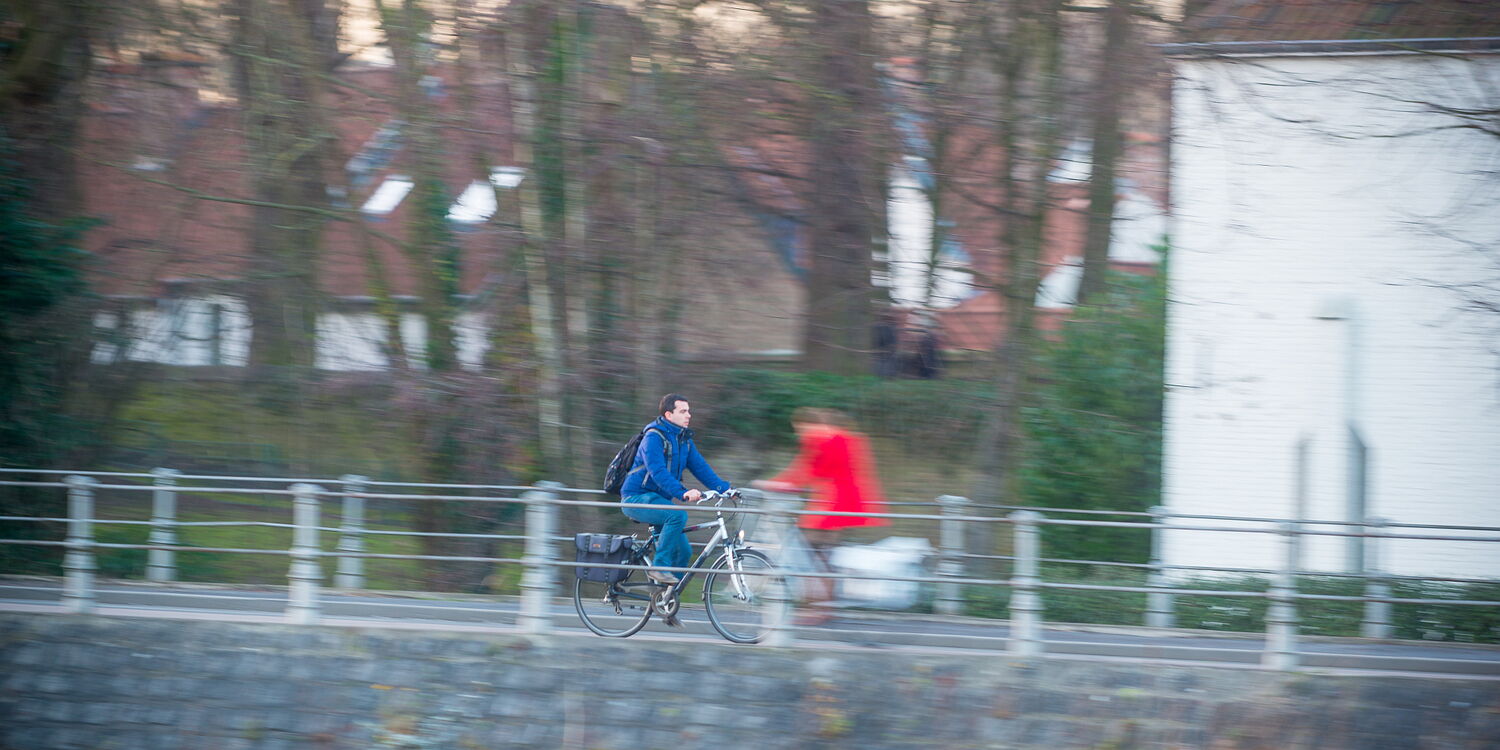 twee fietsers kruisen elkaar op een brug