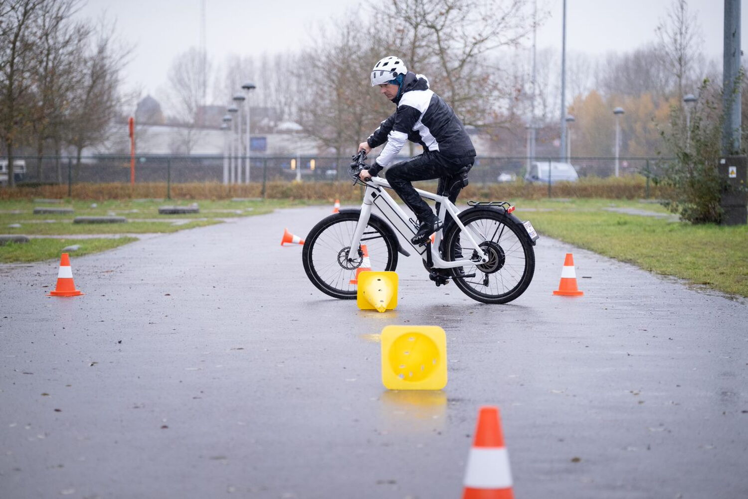 man met speedpedelec rijdt tussen verkeerskegels tijdens een praktijkles