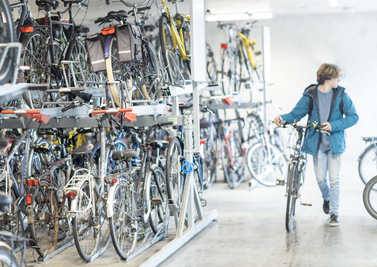 Jonge man loopt grote fietsenstalling binnen