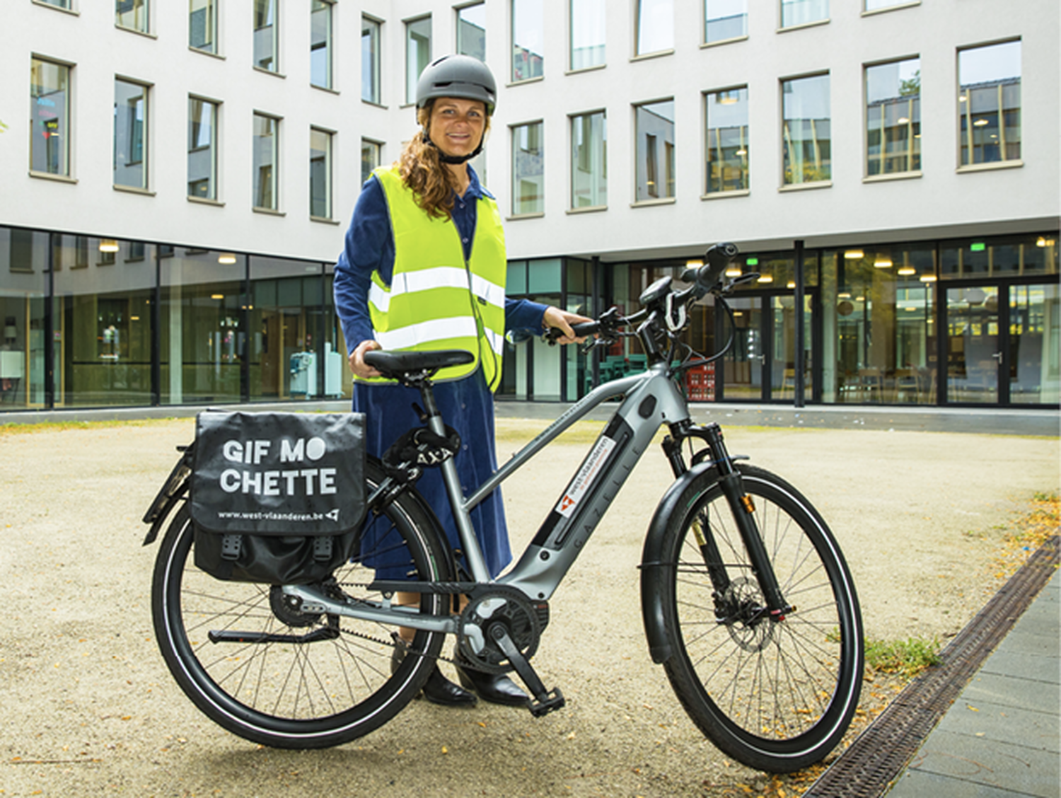 Inge Bultinck poseert met fiets van de testkaravaan aan gebouw GVO 
