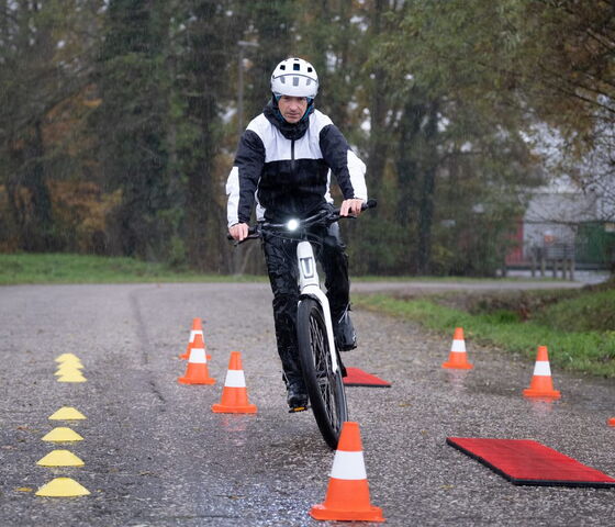 man met speedpedelec rijdt tussen verkeerskegels tijdens een praktijkles