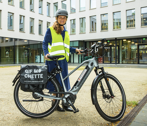 Inge Bultinck poseert met fiets van de testkaravaan aan gebouw GVO 